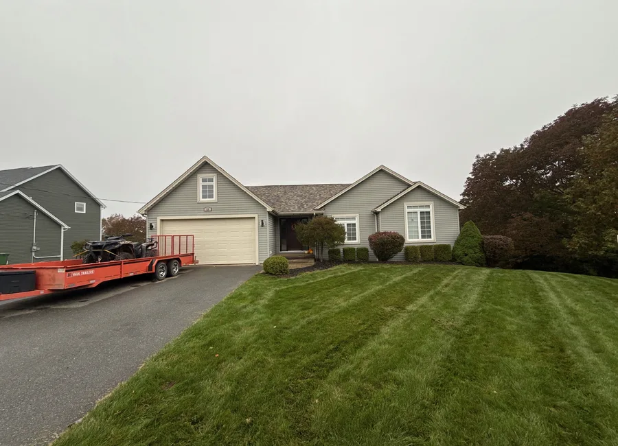 Single storey home with an attached double garage and several roof gables in Quispamsis, New Brunswick.
