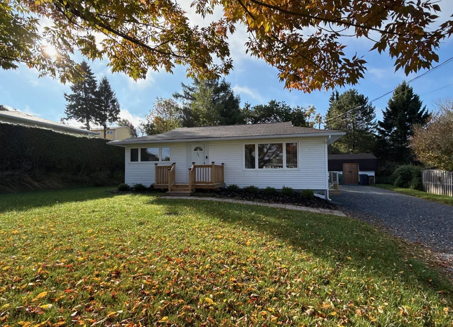 Single storey home with white siding and a low pitched roof in Saint John, New Brunswick